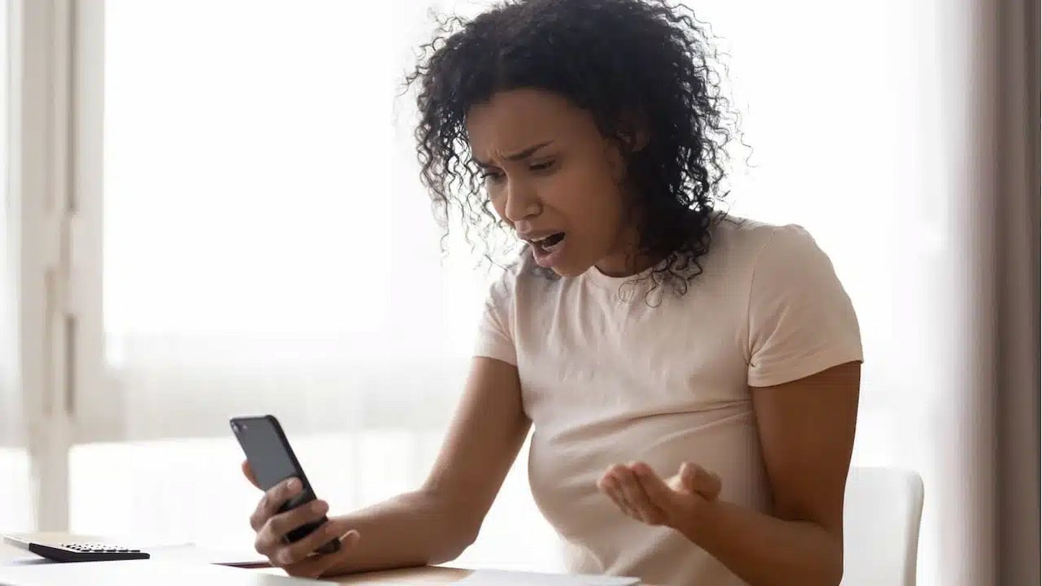 Mulher olhando para o celular com expressão de surpresa e satisfação, simulando a reação ao comprar seguidores e ver o perfil crescer rapidamente.